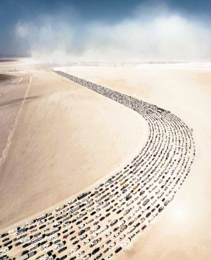 Long line of vehicles winding across a desert road