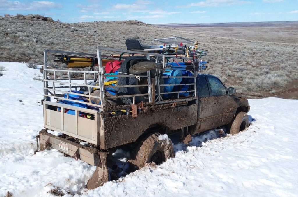 Truck loaded with rafting gear stuck in snow during a remote vehicle shuttle