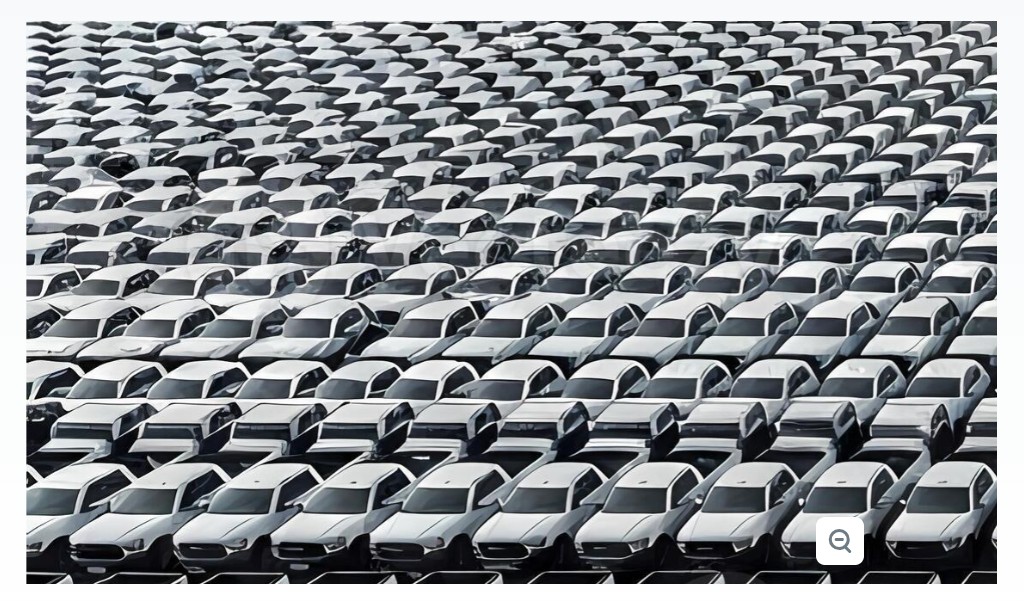 Rows of nearly identical parked vehicles in a large outdoor lot